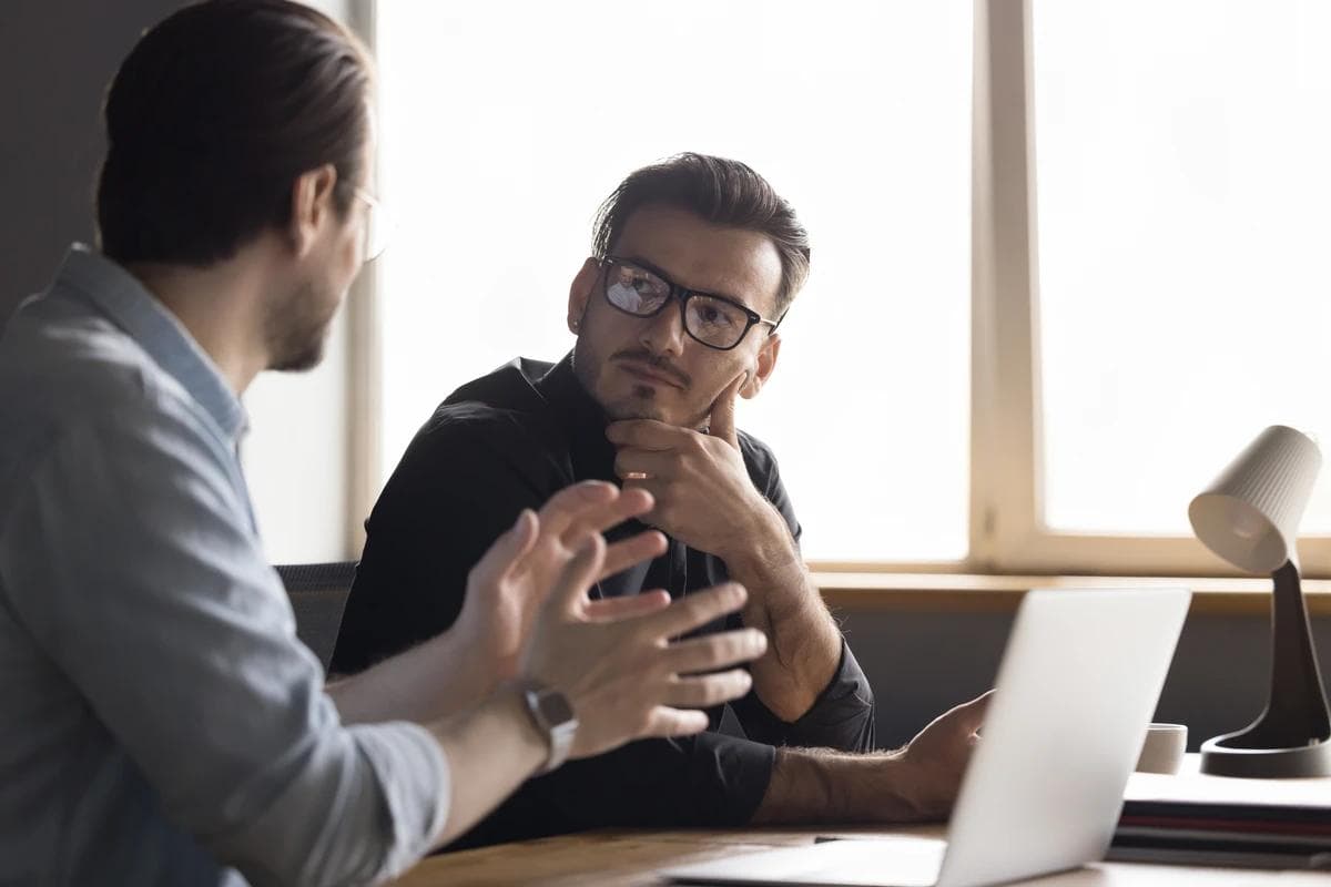 Two work colleagues in a conversation. one intently listening to the other to learn